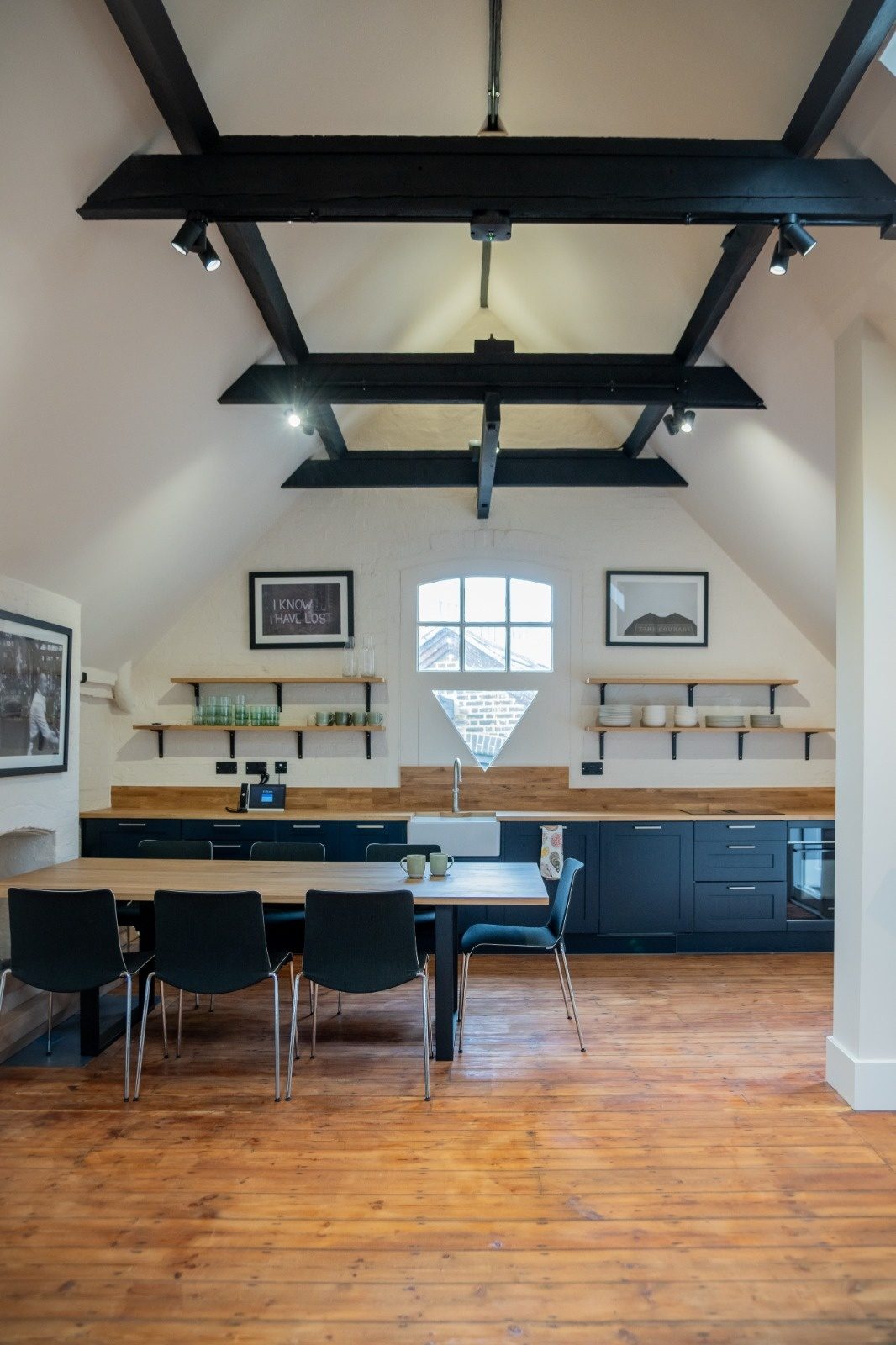 Full house rewire in Loughton with track lighting and downlights under exposed beams in an open-plan kitchen