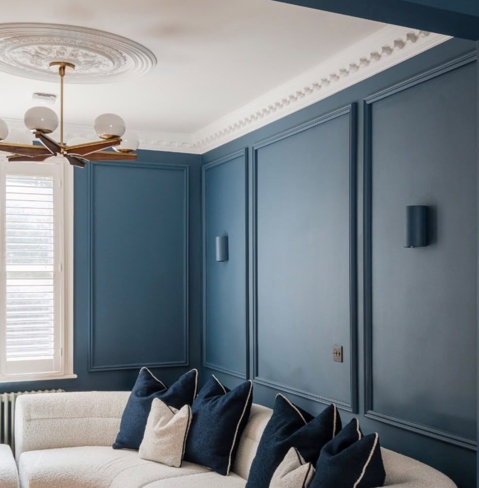 Dimmable wall sconces and chandelier on a smart lighting circuit in a panelled living room