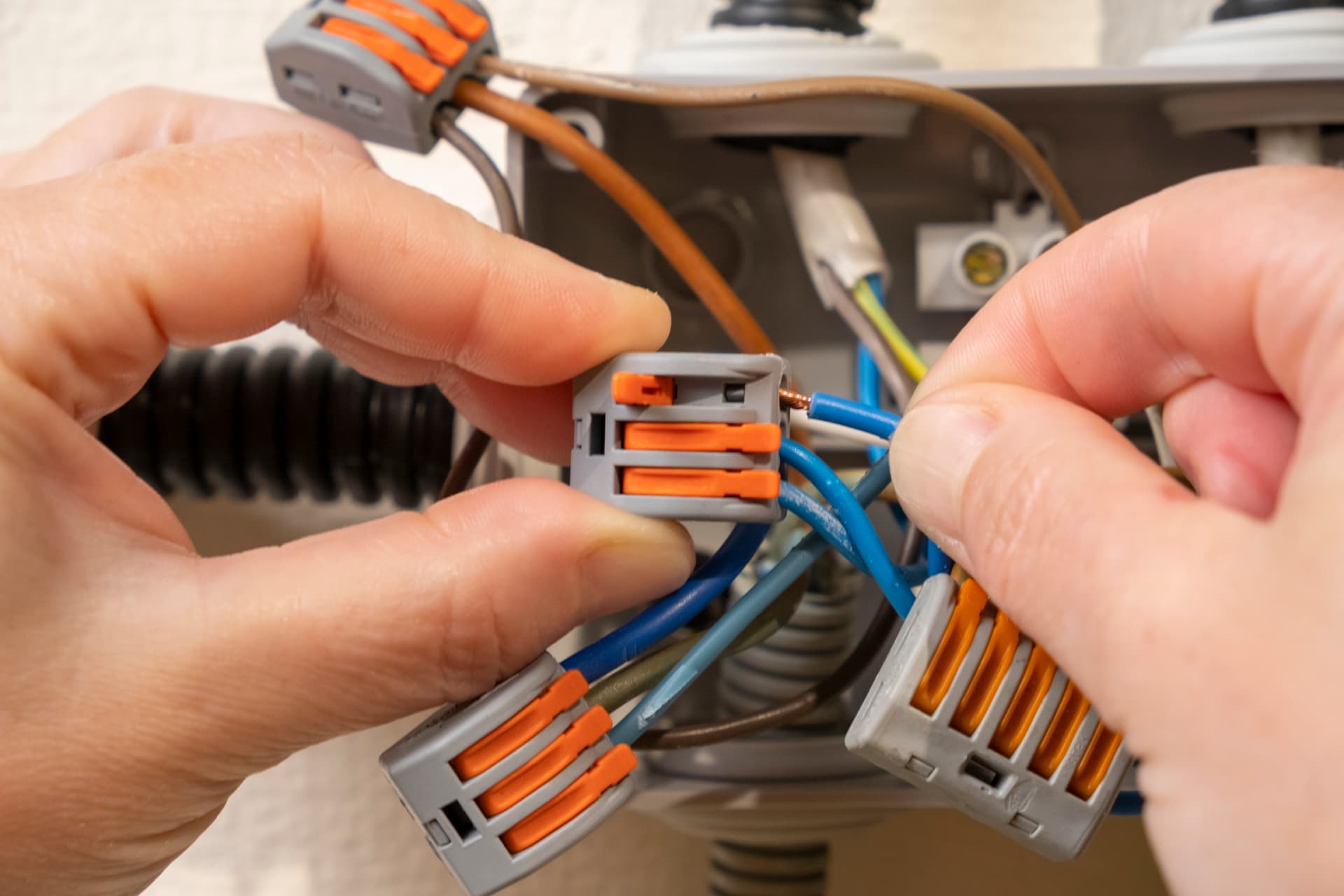 Electrician terminating new lighting and socket circuit cables into lever connectors during a house rewire in Loughton