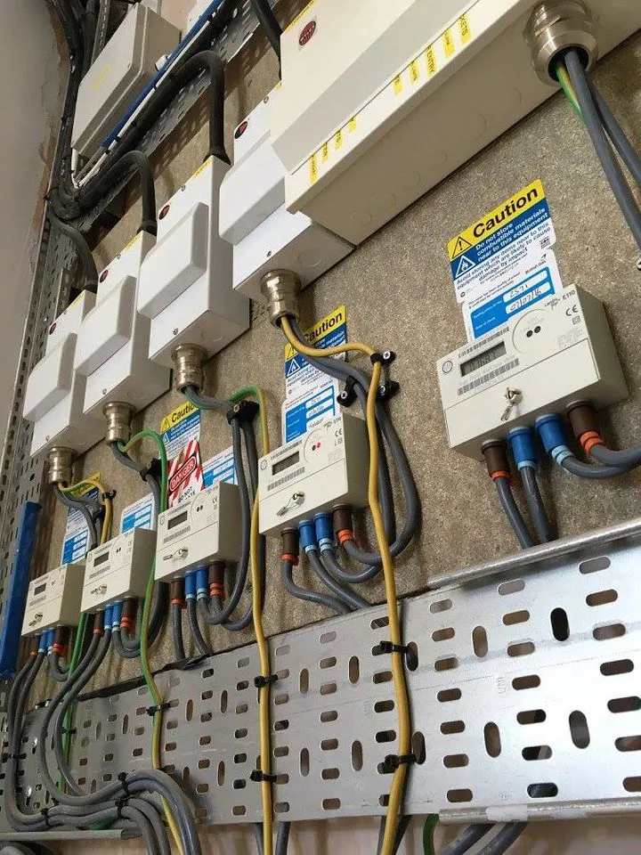 Bank of metered supply isolators and sub-main tails on cable tray being inspected during electrical fault finding